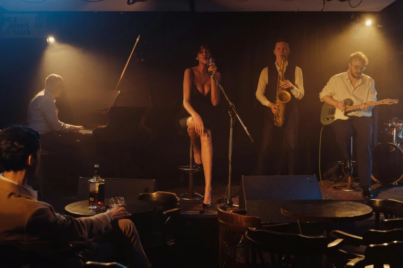 a group of people standing on top of a stage, a portrait, unsplash, art nouveau, film noir jazz bar, sitting in a lounge, band playing, darling in the frank