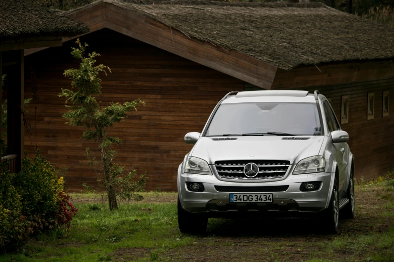 a white mercedes suv parked in front of a cabin, hurufiyya, rustic, avatar image