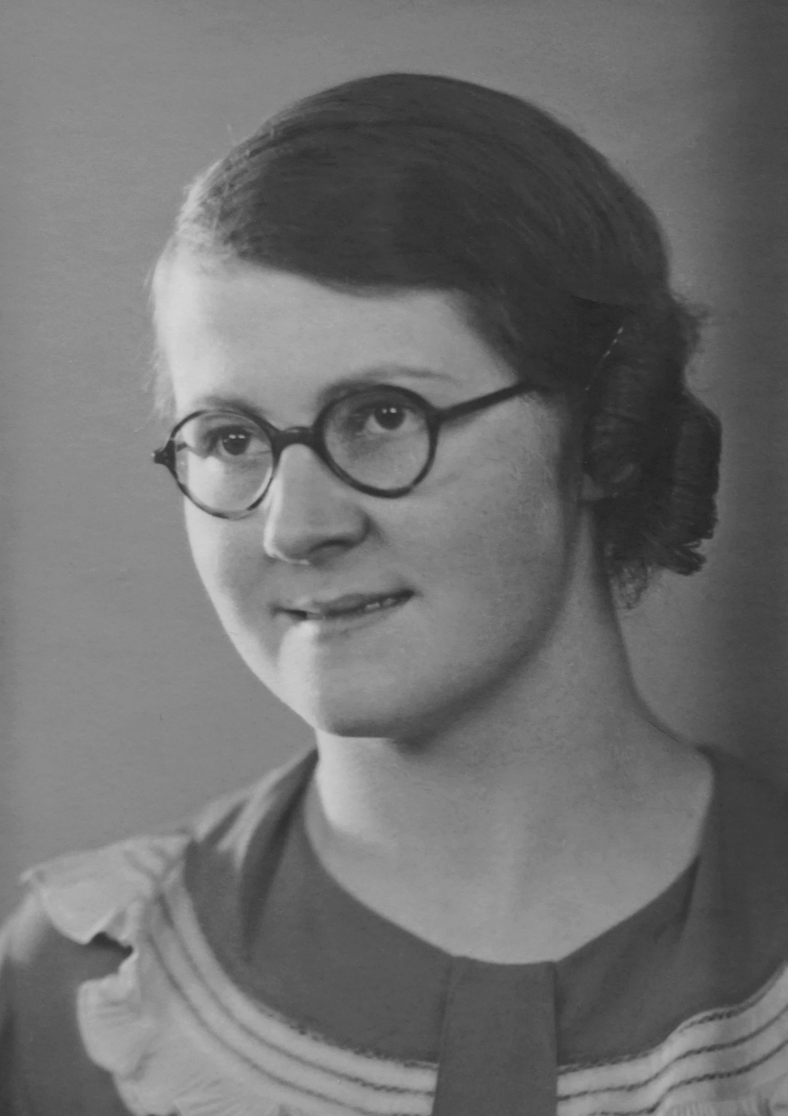 a black and white photo of a woman wearing glasses, a black and white photo, inspired by Elsie Dalton Hewland, early 20s, ernst haekel, mid length portrait photograph, 1 9 3 2