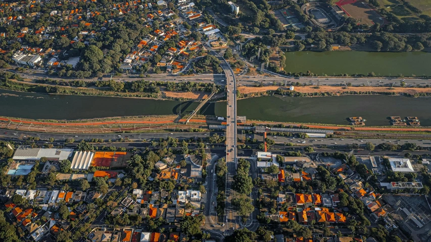 an aerial view of a city next to a river, by Nadir Afonso, pexels contest winner, photorealism, orange line, são paulo, suburb, thumbnail