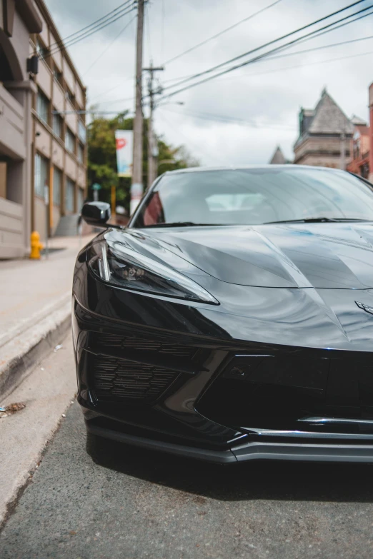 a black sports car parked on the side of the road, by Adam Marczyński, pexels contest winner, stingray, front face, 🚿🗝📝