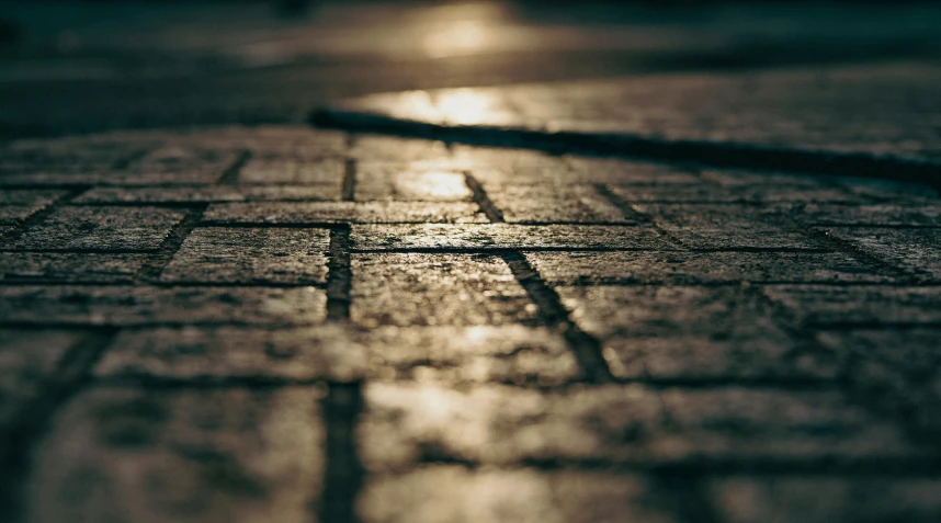the sun shines brightly on a cobblestone street, an album cover, inspired by Elsa Bleda, unsplash, dystopian floor tile texture, close - up bokeh, evening light, brick