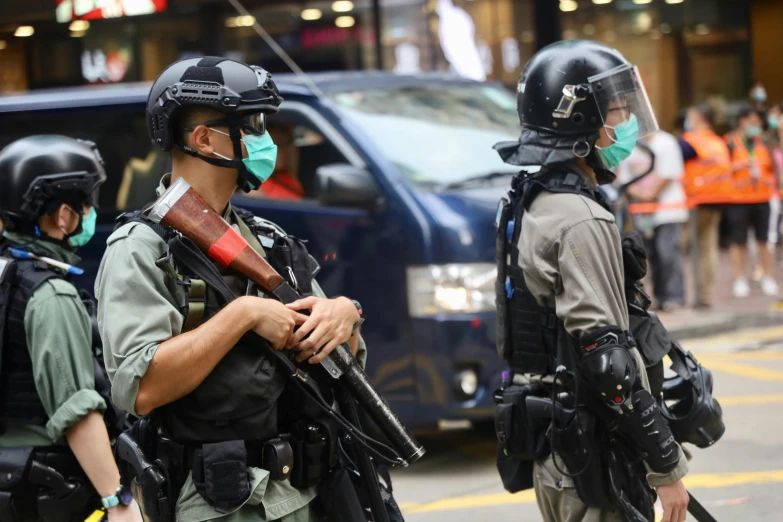 a group of police standing next to each other on a street, holding hk pistol in hand, wearing facemask, white helmet, profile image