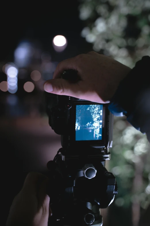 a close up of a person holding a camera, unsplash, video art, nighttime foreground, low iso, fujifilm”, night cam footage