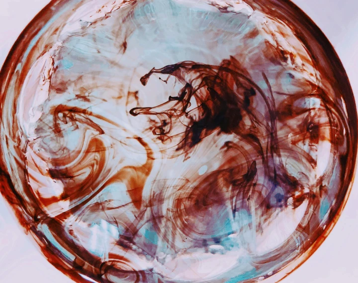 a glass bowl sitting on top of a table, an abstract drawing, inspired by Otto Piene, pexels, process art, mocha swirl color scheme, shot from below, brown red blue, abstraction chemicals