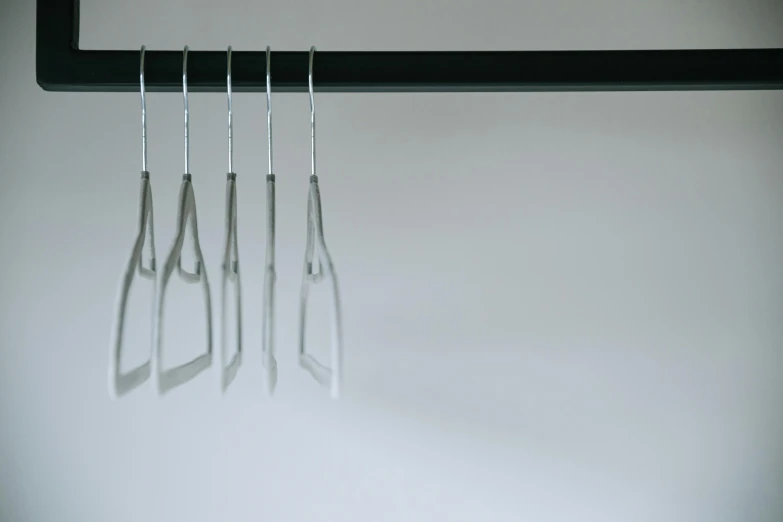 a pair of scissors hanging from a hook, a 3D render, inspired by Cornelia Parker, unsplash, purism, glass obelisks, 3d printed, in a row, cast