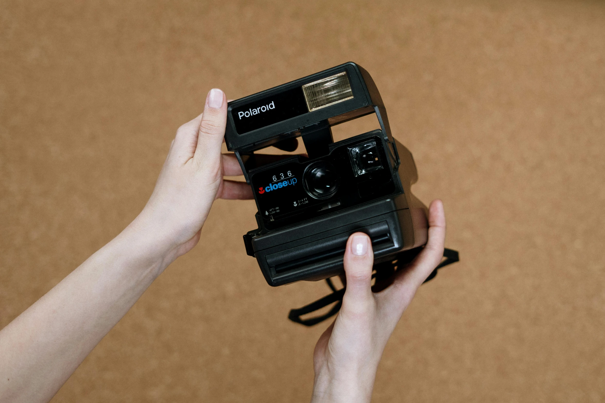 a person holding a polaroid camera in their hand, inspired by Elsa Bleda, unsplash, fan favorite, polaroid 6 0 0 film, cardboard, holding controller