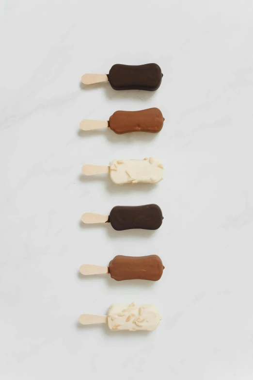 a group of ice creams sitting on top of each other, ivory and copper, 6 pack, dark brown, medium - shot