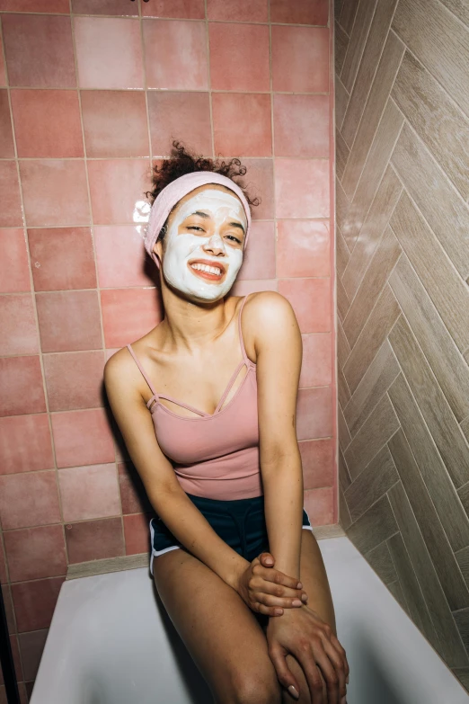 a woman sitting in a bathtub with a face mask on, by Olivia Peguero, trending on pexels, wearing a pink head band, mixed race woman, joyful smirk, beauty campaign