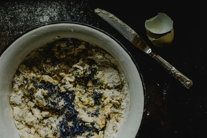 a bowl of food sitting on top of a wooden table, a portrait, unsplash, process art, flour dust, blue and white and gold, ignant, digging