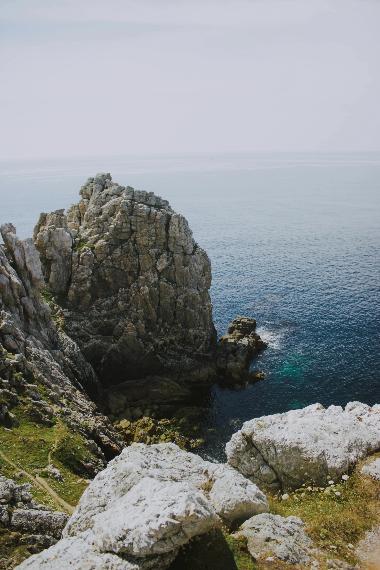 a man standing on top of a cliff next to the ocean, les nabis, piroca, multiple stories, distant photo