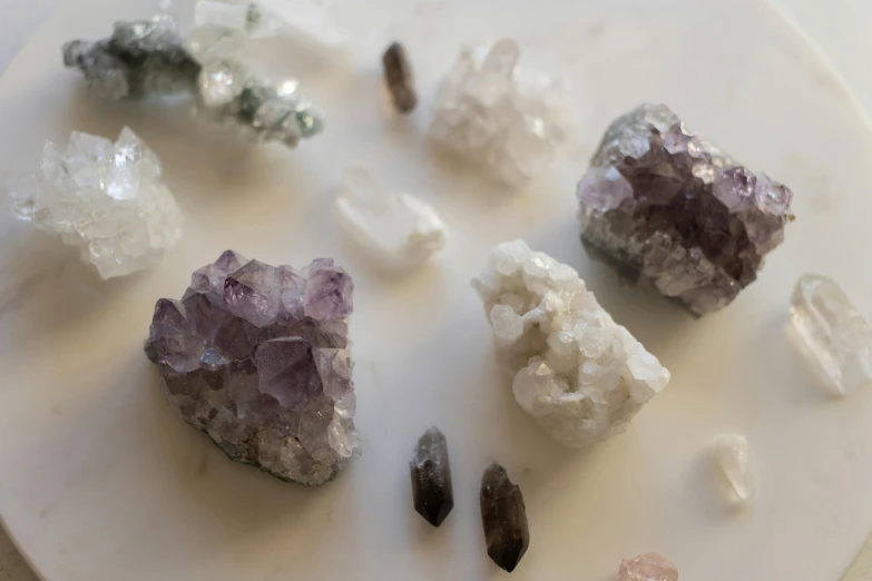 a white plate topped with lots of different colored crystals, trending on pexels, white and purple, ((rocks)), portrait shot, grey