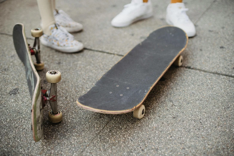 a couple of skateboards sitting next to each other, trending on unsplash, hyperrealism, sydney sweeney, some of the blacktop is showing, adrian tomine, 90s photo