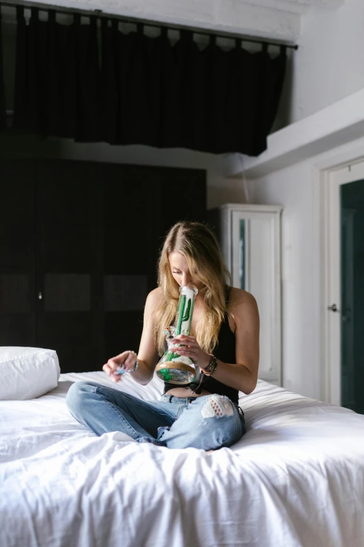 a woman sitting on a bed reading a book, smoking a magical bong, green arms, sydney sweeney, bottle