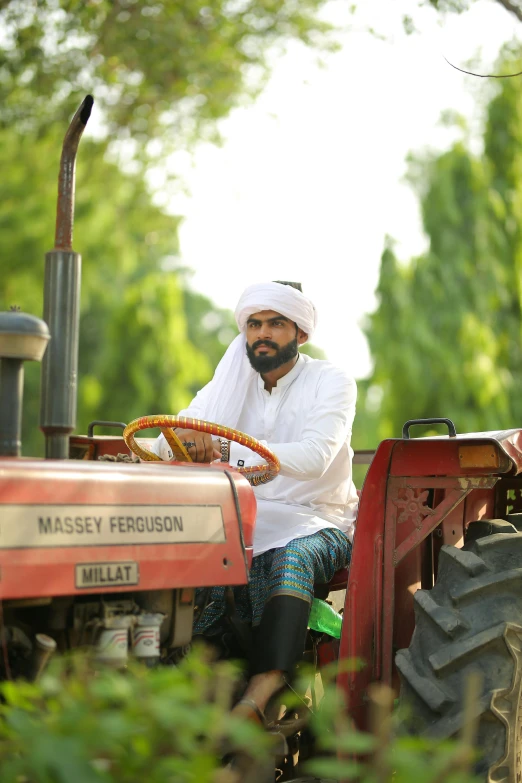 a man sitting on top of a red tractor, an album cover, inspired by Manjit Bawa, hurufiyya, sheikh mohammed ruler of dubai, 2 5 6 x 2 5 6 pixels, lush farm lands, ( ( theatrical ) )