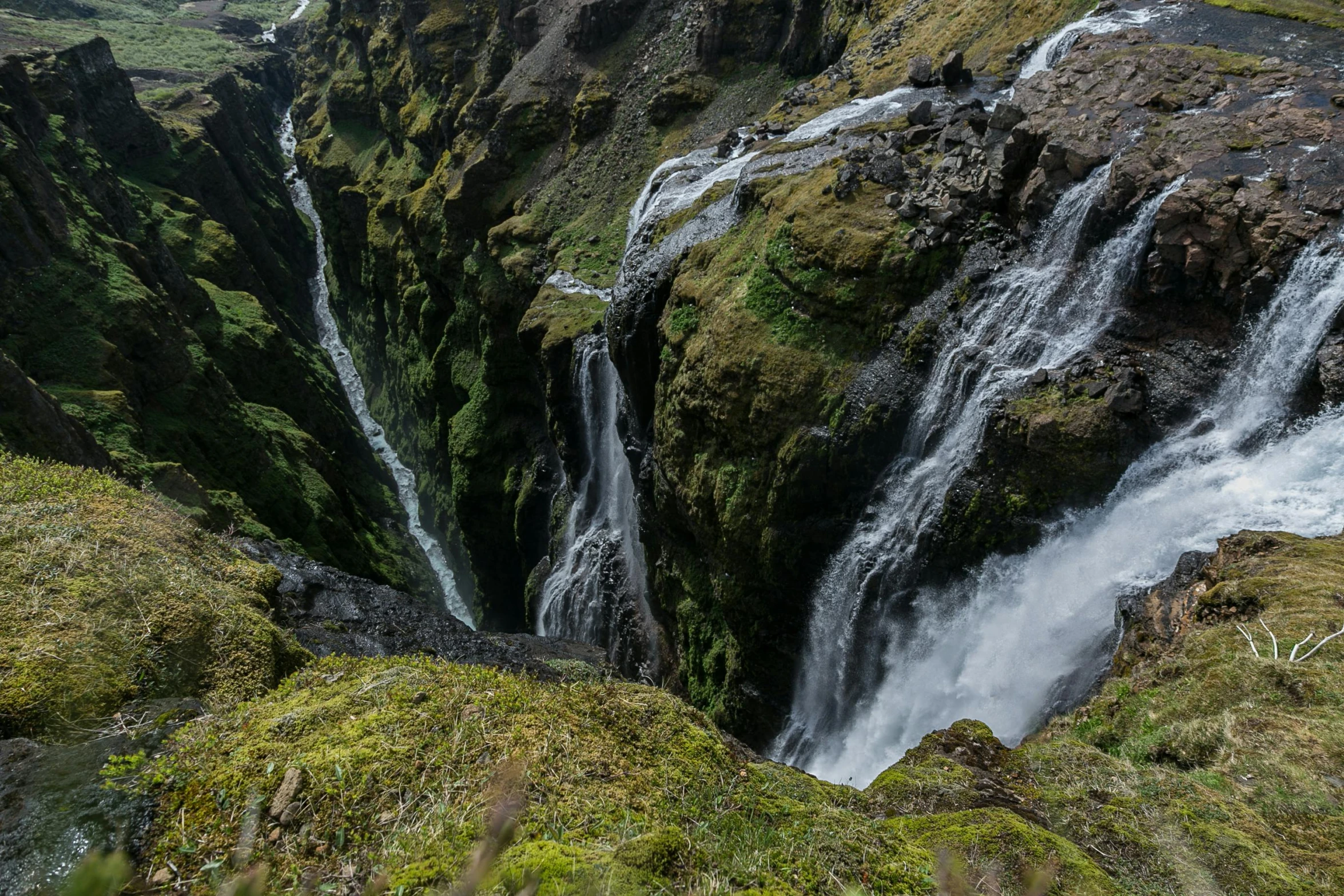 a man standing on top of a cliff next to a waterfall, by Hallsteinn Sigurðsson, pexels contest winner, hurufiyya, high view, thumbnail, detailed photo 8 k, multiple stories