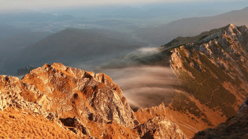 a group of people standing on top of a mountain, a picture, inspired by Michal Karcz, unsplash contest winner, romanticism, “ aerial view of a mountain, golden mist, summer evening, mount olympus