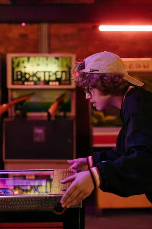 a couple of people playing a game of pinball, an album cover, pexels, yung lean, finn wolfhard, programmer, profile photo