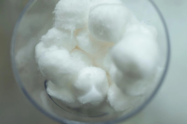 a blender filled with white sugar sitting on top of a counter, by Adam Marczyński, unsplash, process art, puffballs, lined in cotton, made of lab tissue, high angle close up shot