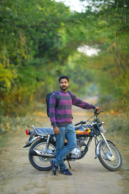 a man standing next to a motorcycle on a dirt road, a picture, by Manjit Bawa, 2 5 6 x 2 5 6 pixels, headshot profile picture, around 1 9 years old, autumn season