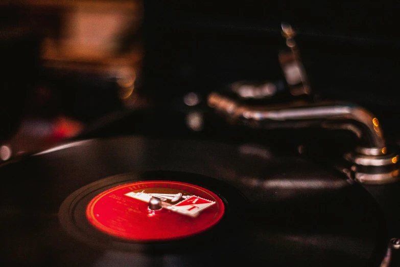 a close up of a record on a table, by Daniel Lieske, trending on pexels, silver white gold red details, 1 9 3 0 s jazz club, colour photograph, tiny details