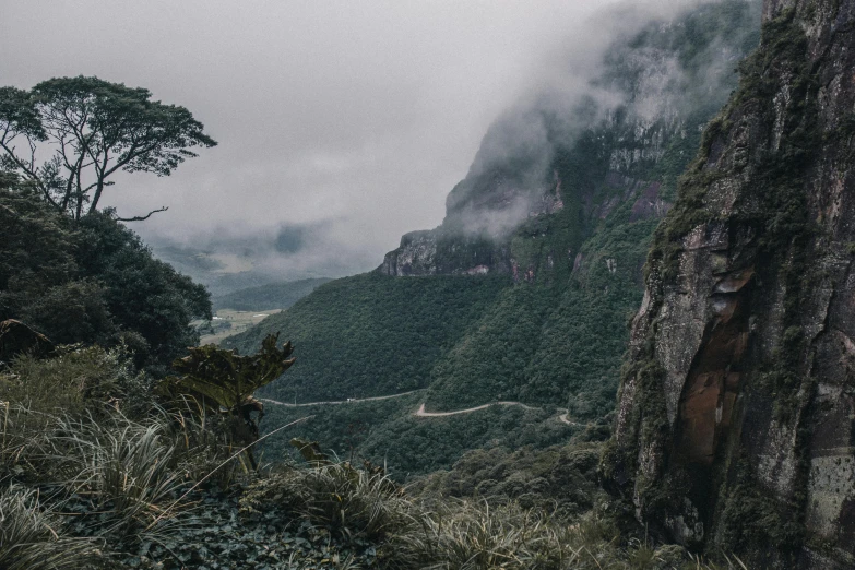 the view from the top of a mountain on a cloudy day, pexels contest winner, te pae, trees and cliffs, hidden valley, grey