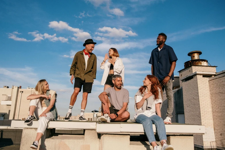 a group of people sitting on top of a roof, a portrait, by Lee Loughridge, pexels contest winner, photoshoot for skincare brand, good times, very tall, looking to the side