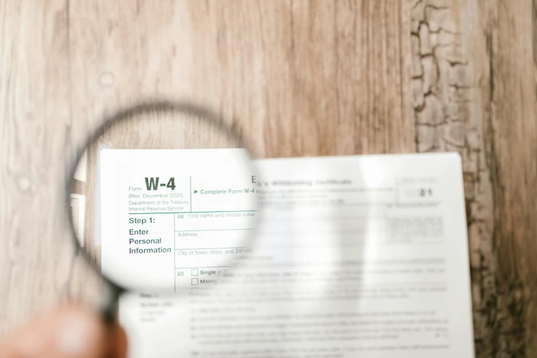 a close up of a person holding a magnifying glass, uses c4, papers, the letter w, worksafe. instagram photo