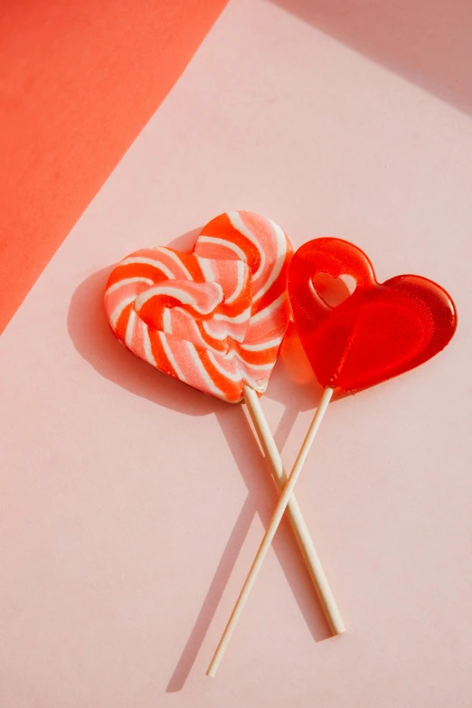 a couple of lollipops sitting on top of each other, by Valentine Hugo, trending on pexels, light red and orange mood, made of candy, bright ”, barbara canepa