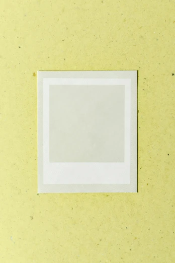 a picture frame sitting on top of a yellow wall, a polaroid photo, inspired by Zhang Kechun, trending on pexels, square sticker, pale green glow, paper texture, 15081959 21121991 01012000 4k