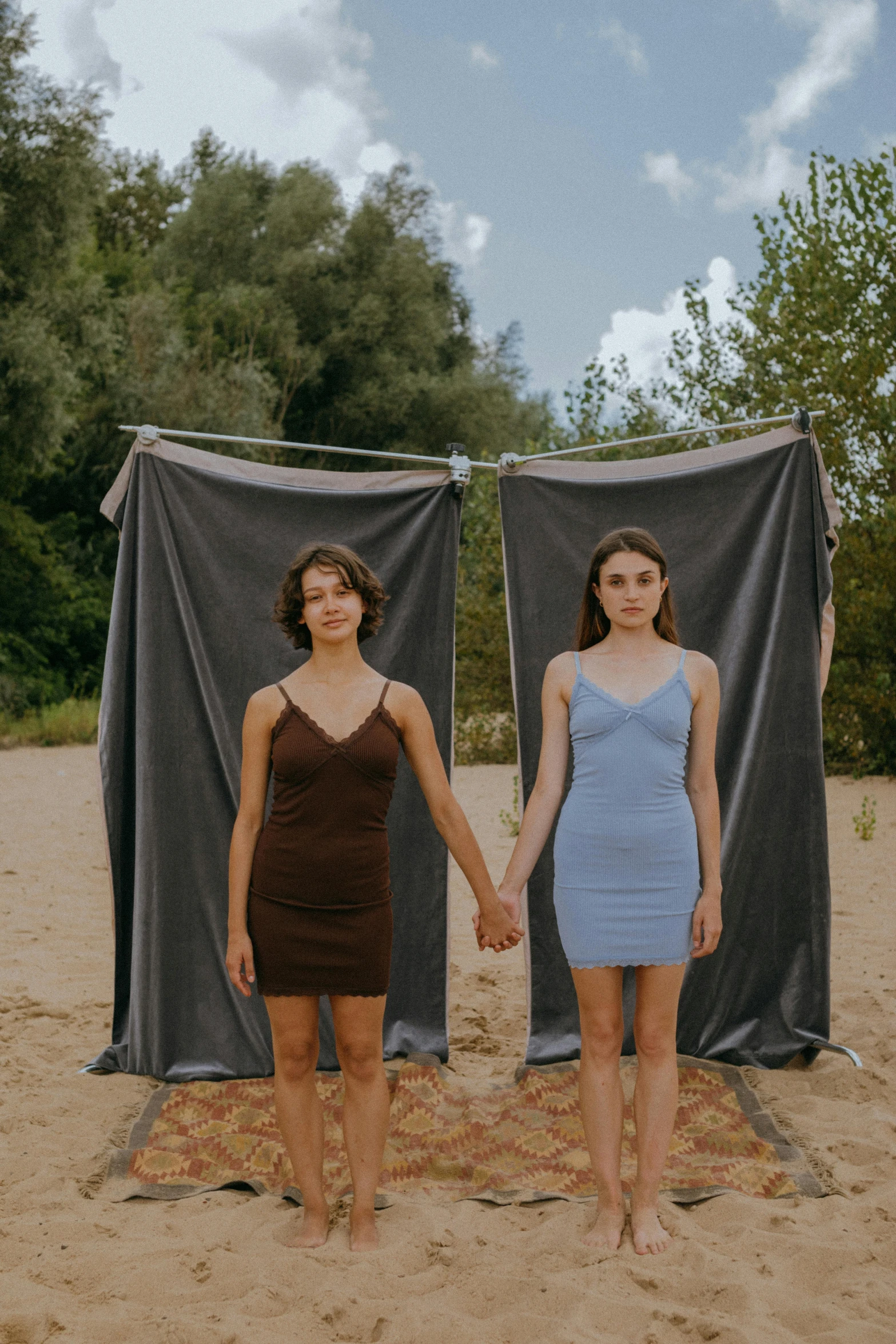 two women standing next to each other on a beach, an album cover, by Attila Meszlenyi, jovana rikalo, young and slender, photograph taken in 2 0 2 0, festivals