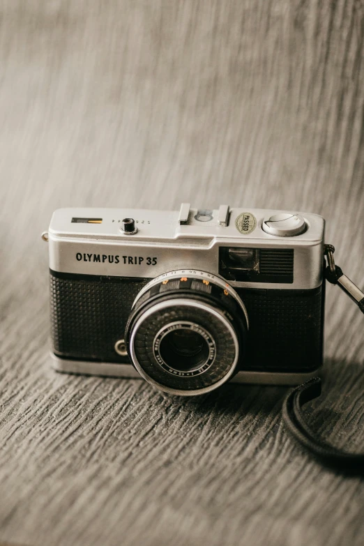 a black and white photo of a camera, by David Simpson, unsplash contest winner, photorealism, 35mm film color photography, olympus, vintage old, today\'s featured photograph 4k