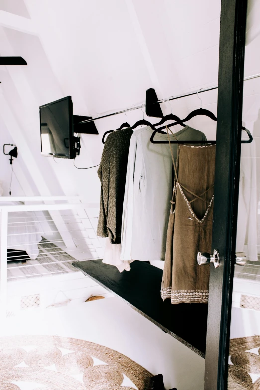 a room with clothes hanging on a clothes rack, a colorized photo, unsplash, light and space, glamping, dressed in a top and shorts, cinematic outfit photo, pov photo