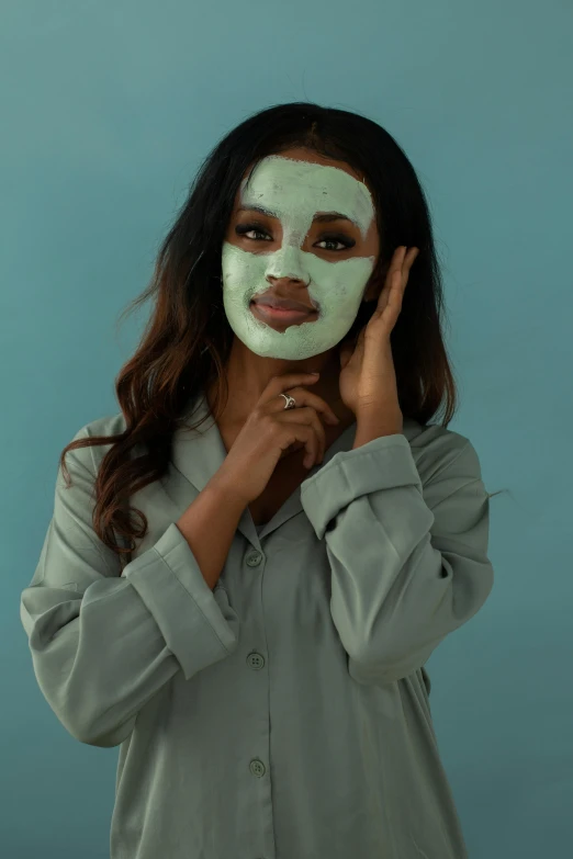 a woman holding a face mask in front of her face, trending on pexels, pastel green, beauty campaign, jasmine, frontal pose