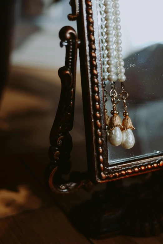 a close up of a mirror with pearls on it, a still life, by Elsa Bleda, unsplash, baroque, long earrings, 1 9 1 0 s style, full frame image, wedding photo