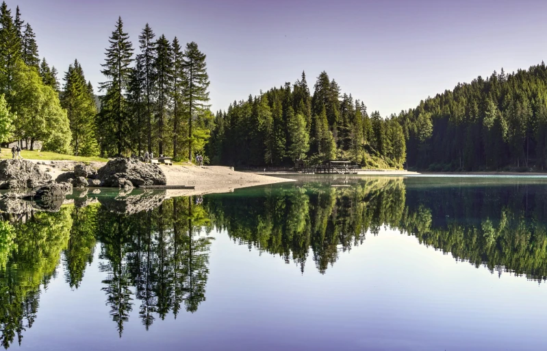 a large body of water surrounded by trees, by Karl Walser, pexels contest winner, fan favorite, switzerland, clear reflection, summer lake setting