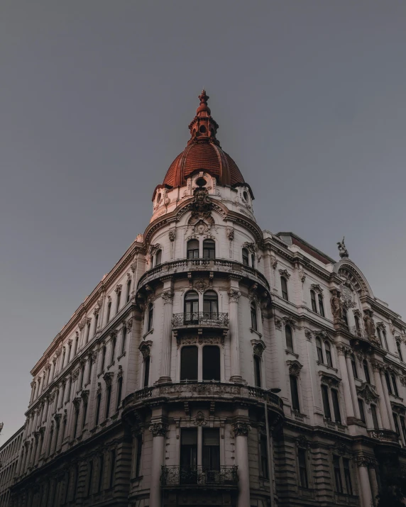 a tall building with a clock on top of it, inspired by Mihály Munkácsy, unsplash contest winner, art nouveau, buenos aires, domes, early evening, split near the left