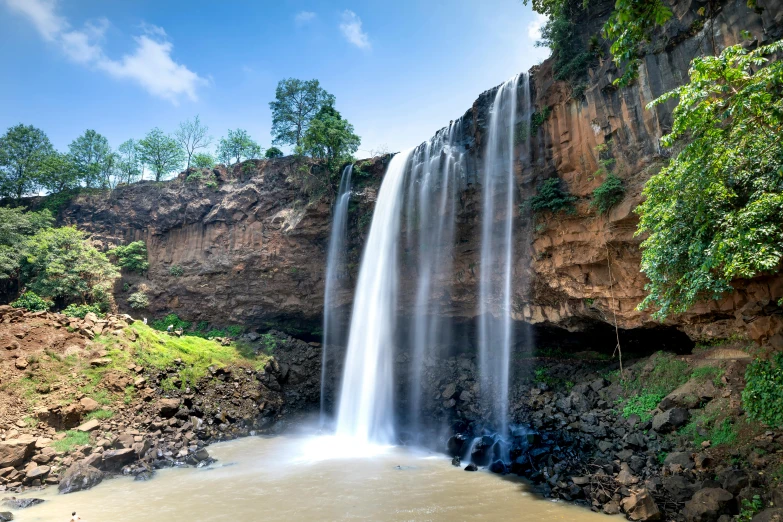 a waterfall in the middle of a lush green forest, hurufiyya, somalia, fan favorite, exterior photo