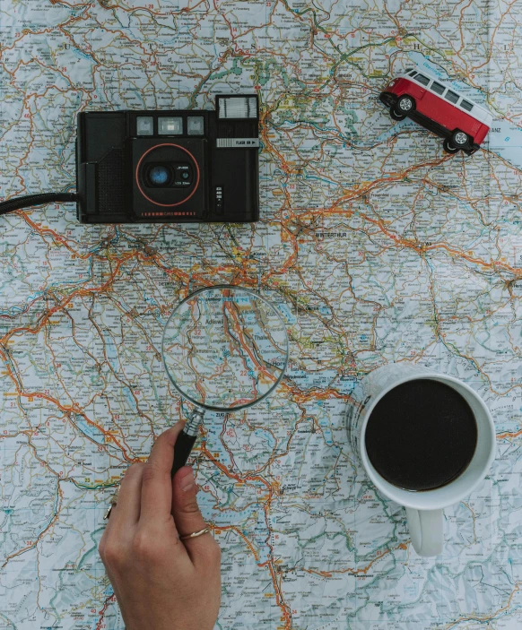 a person holding a camera on top of a map, a polaroid photo, by Carey Morris, pexels contest winner, vehicle, panel, (by tom purvis), throw