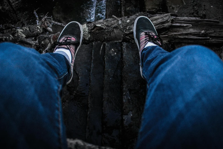 a person wearing blue jeans and black sneakers, a picture, pexels contest winner, sitting on a log, creepy vibe, gopro photo, insanly detailed
