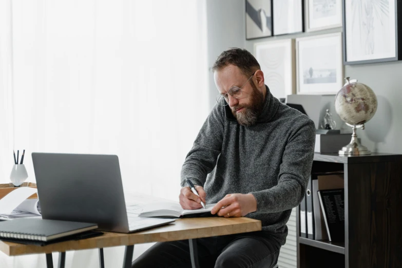 a man sitting at a desk working on a laptop, pexels contest winner, grey, writing on a clipboard, middle aged man, lachlan bailey