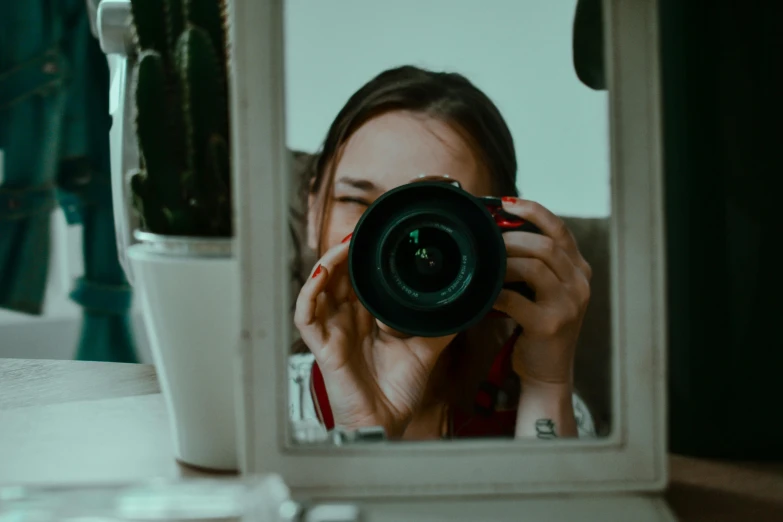 a woman taking a picture of herself in a mirror, pexels contest winner, photorealism, lovingly looking at camera, magnification, cameras lenses, looking through a window frame