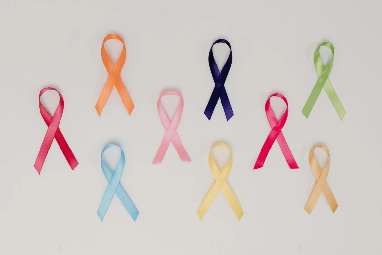 a number of different colored ribbons on a white surface, a cartoon, pexels, antipodeans, the cure for cancer, profile image, nursing, full body image