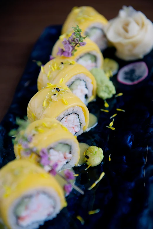 a close up of a plate of food on a table, a pastel, inspired by Maki Haku, unsplash, mingei, yellow, stuffed, cosmopolitan, 2995599206