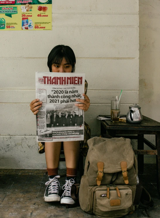 a boy sitting on a bench reading a newspaper, a poster, trending on unsplash, happening, vietnam war, of a schoolgirl posing, contest winner 2021, on the cover of a magazine