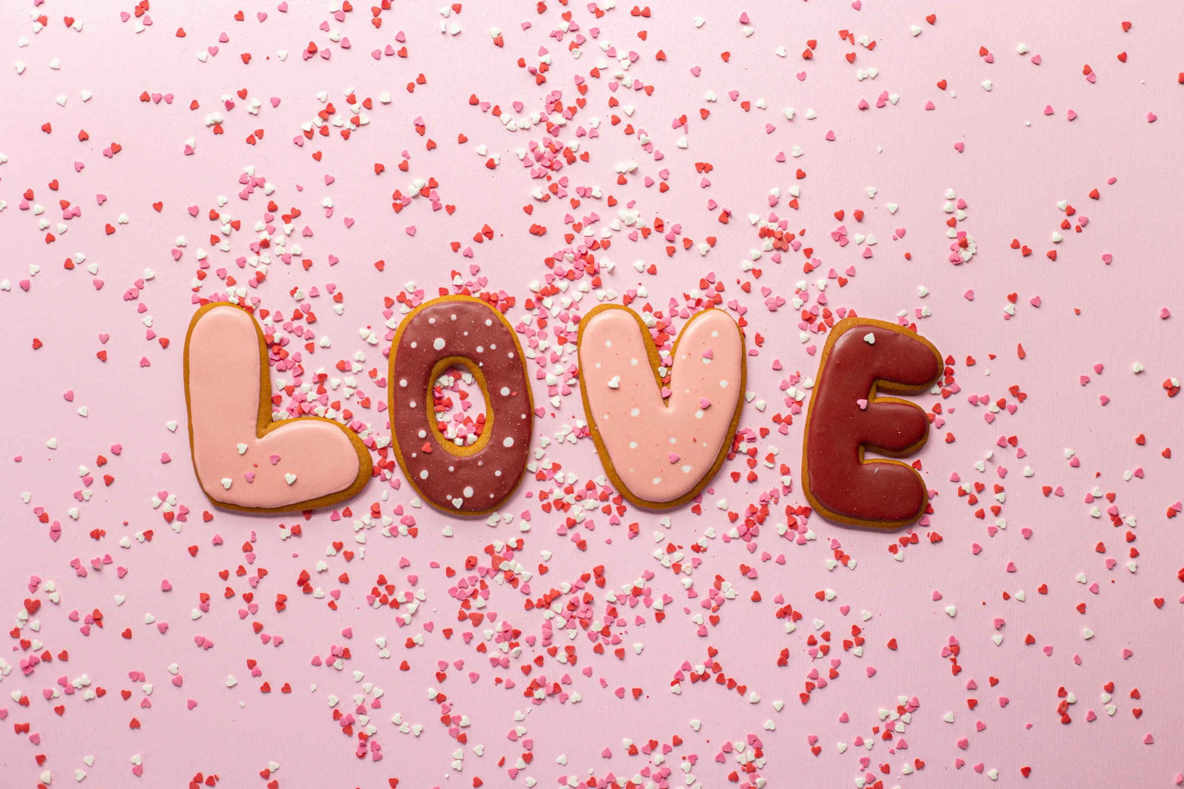 the word love spelled in chocolate and sprinkles on a pink background, by Julia Pishtar, pexels, graffiti, cookies, background image, ginger, fanart