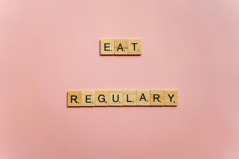 the word eat regularly spelled with scrabbles on a pink background, by Ellen Gallagher, pexels, 🦩🪐🐞👩🏻🦳, cedar, clean minimalist design, ƒ/5.6