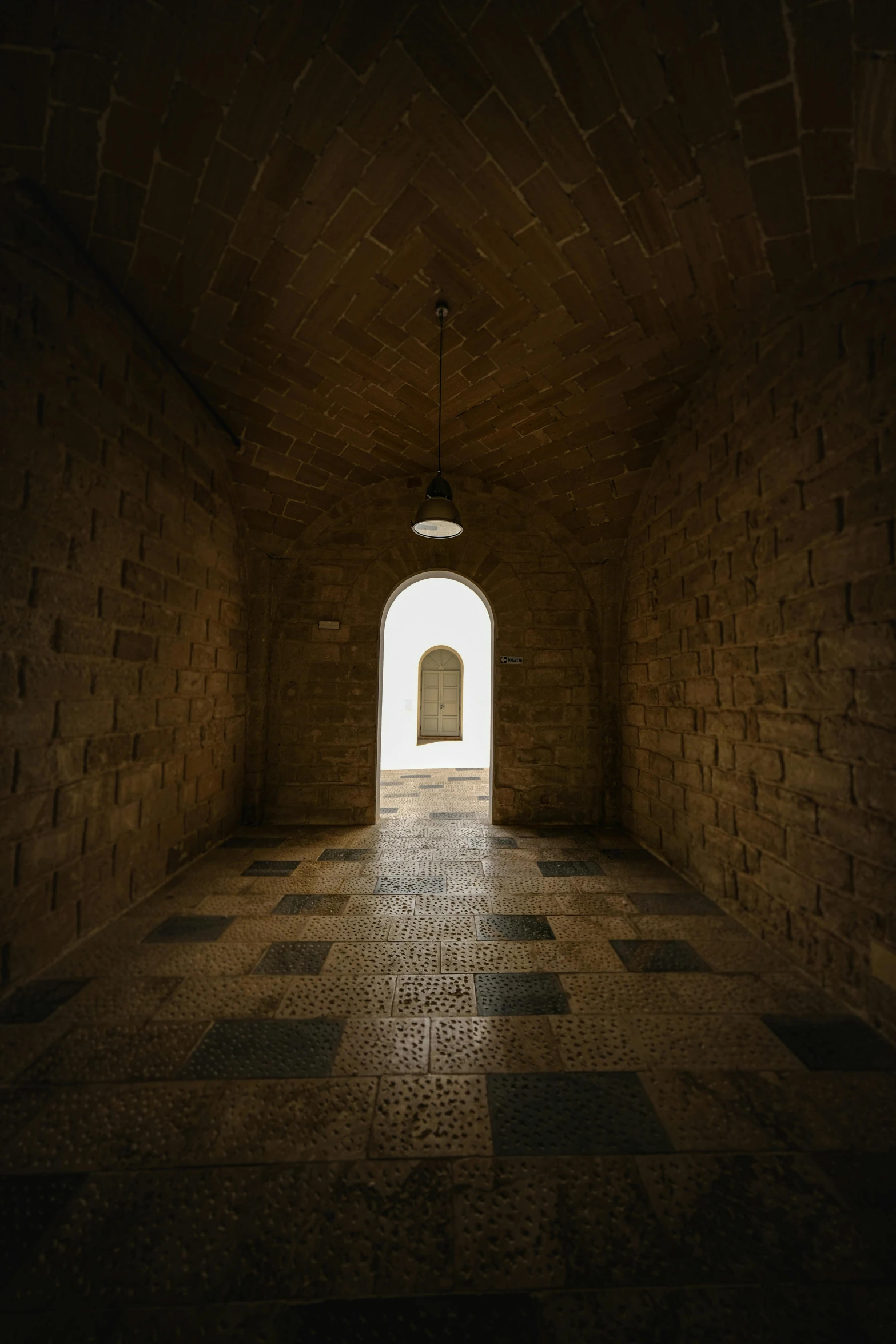 a dark tunnel with a light at the end, an album cover, unsplash contest winner, light and space, ancient stone tiling, conversano, brown, bright white castle stones