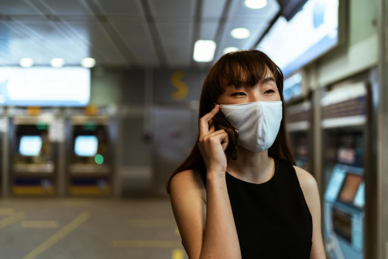 a woman wearing a face mask while talking on a cell phone, by Julia Pishtar, pexels contest winner, hong kong, avatar image, gemma chan girl portrait, underground scene