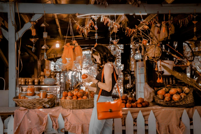 a woman standing in front of a fruit stand, pexels contest winner, holding a leather purse, orange lights, dreamy scene, 🦩🪐🐞👩🏻🦳